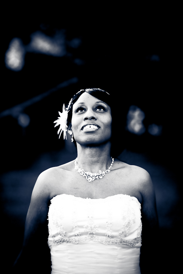 Black and white photo with blue tint - Gorgeous dramatic photo of beautiful bride wearing white strapless dress and floral hairpiece while looking up towards the sky - photo by North Carolina based wedding photographer Jeremie Barlow